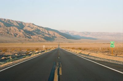 Empty road along countryside landscape