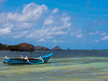 Boat moored on sea against sky