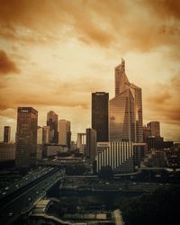 Modern cityscape against sky during sunset