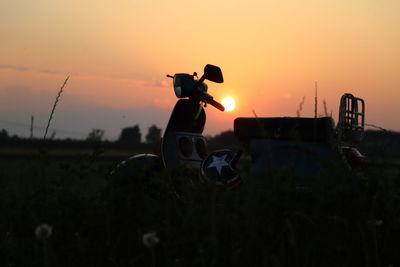 Silhouette man on field against sky during sunset