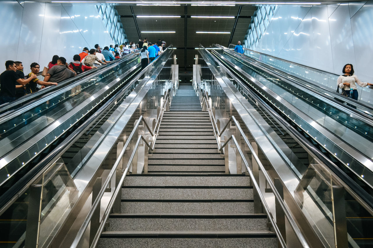 PEOPLE ON ESCALATOR IN ILLUMINATED UNDERGROUND