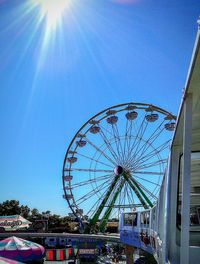 Low angle view of ferris wheel against blue sky