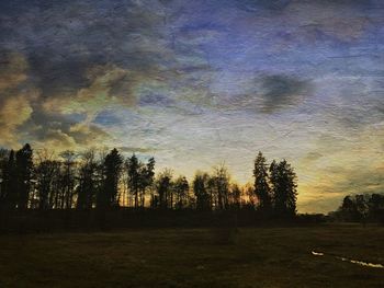 Silhouette trees on landscape against sky at sunset