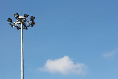 Low angle view of floodlight against blue sky