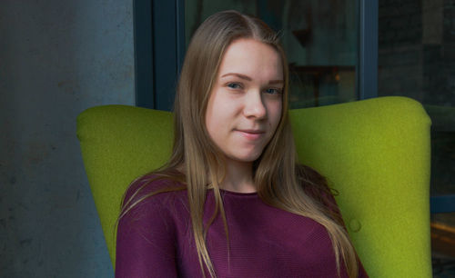 Portrait of young woman sitting on chair