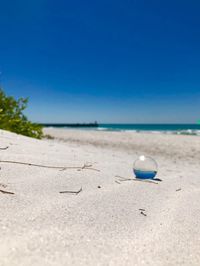 Close-up of beach against clear blue sky
