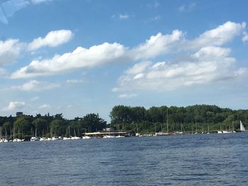 Sailboats moored in sea against sky