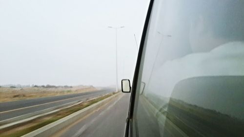 Road amidst agricultural field against clear sky