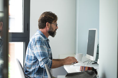 Side view of man working in office