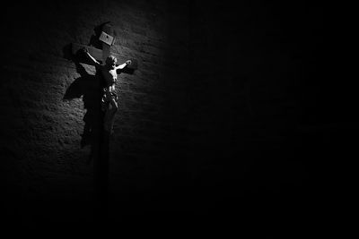 Low angle view of silhouette person against illuminated wall