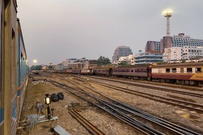 Railroad tracks amidst buildings in city against sky