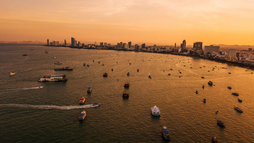 High angle view of buildings and sea against sky during sunset