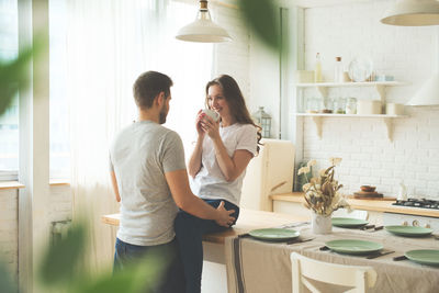 Side view of young couple holding table