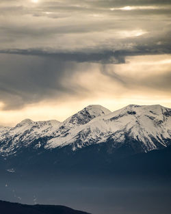 Scenic view of snowcapped mountains against sky during sunset