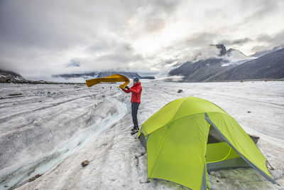 Mountaineer setting up tent on glacier on baffin island.