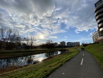 Road by lake against sky in city