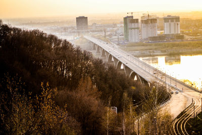 Bridge over city against sky during sunset