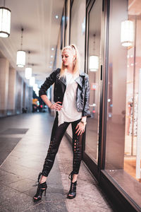 Full length of woman standing in illuminated corridor