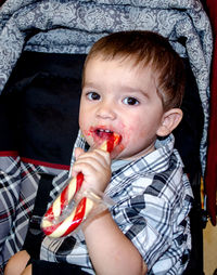 Toddler with a sweet candy cane and a sticky face and hands