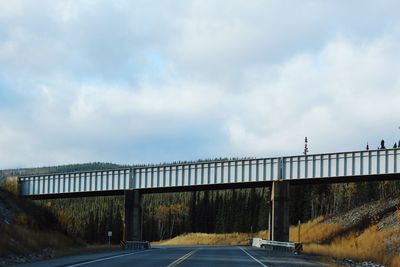 Road by bridge against sky