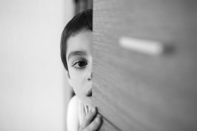 Portrait of boy peeking at home