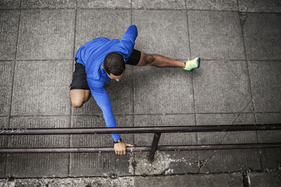 High angle view of exercising by railing on street