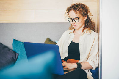 Young woman using digital tablet while sitting at home