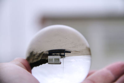 Close-up of human hand holding crystal ball outdoors