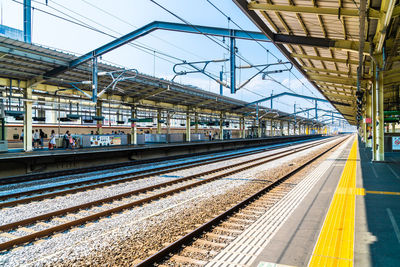 Railroad station platform in city against sky