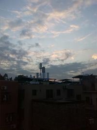 Buildings against cloudy sky at sunset