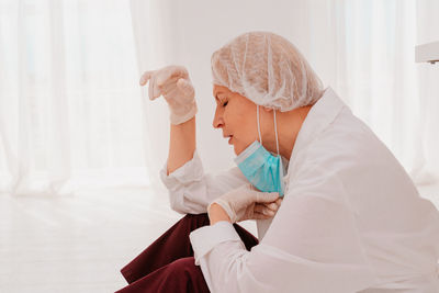 Side view of tired doctor sitting at hospital