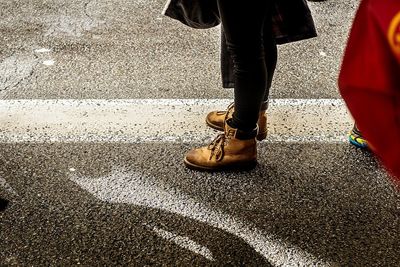 Low section of man walking on road