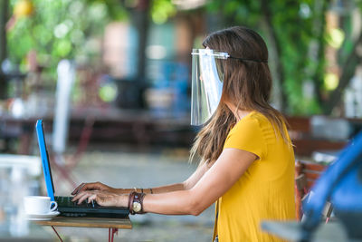 Rear view of woman using mobile phone