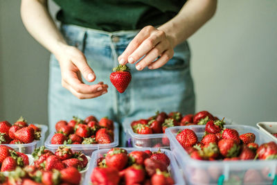 Midsection of woman holding strawberries