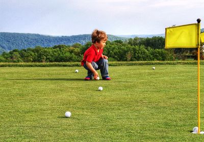 Full length of boy playing with ball in park