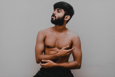 Young man looking away against white background