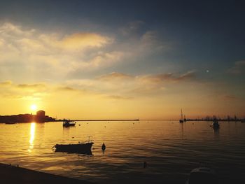 Silhouette boat in sea against sky during sunset