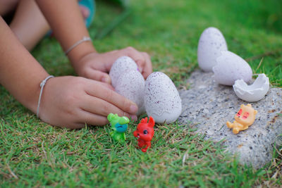 Close-up of hand holding small toy on field