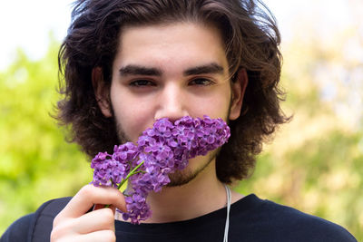 Portrait of smiling man holding purple flower