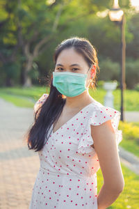 Portrait of beautiful asian woman with face mask in the public park
