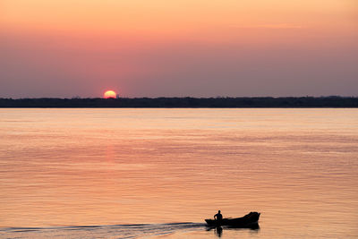 Scenic view of lake against orange sky