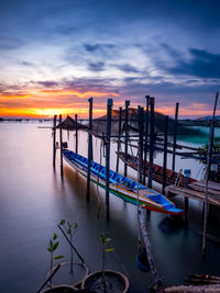 Boats in sea against sky during sunset