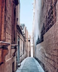 Narrow alley amidst buildings against sky