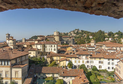 Aerial view through a stone arch, of the old town of bergamo, italy