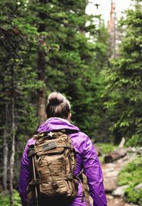 Rear view of woman walking in forest