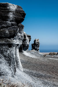 Rock formations against clear blue sky
