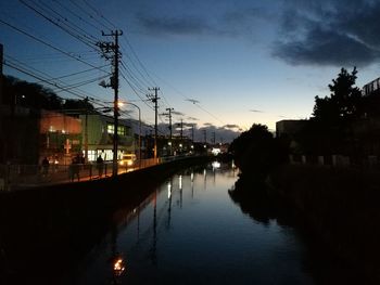 Silhouette of electricity pylon at night