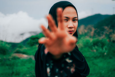 Portrait of beautiful woman standing on field