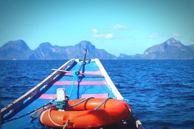 Boat moored on sea against clear blue sky