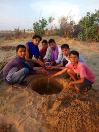 Portrait of friends sitting on land